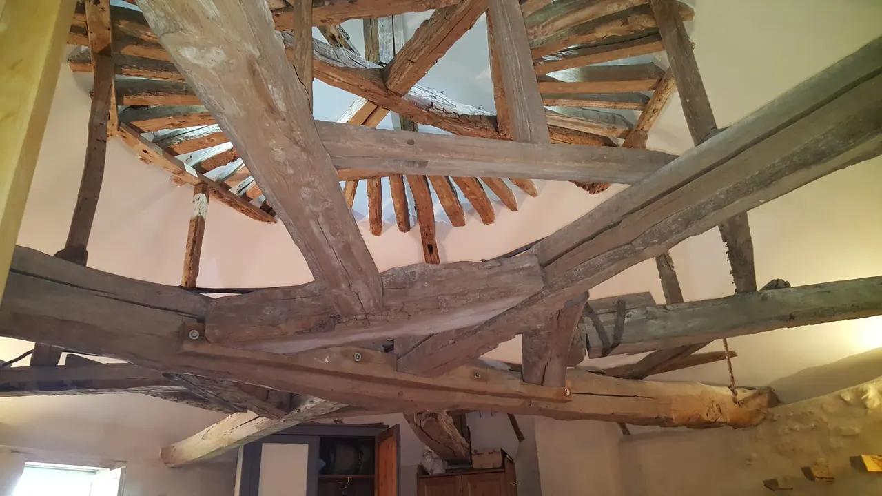 Charpente ancienne en étoile restaurée et mise en valeur