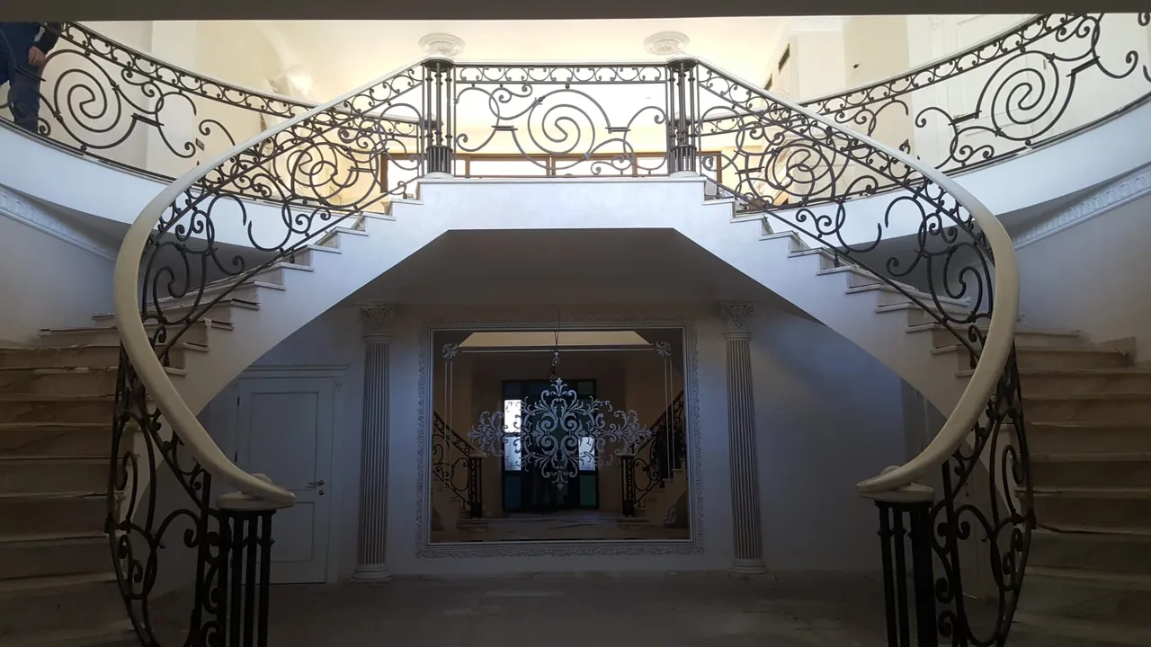 Escalier monumental double avec garde-corps en fer forgé
