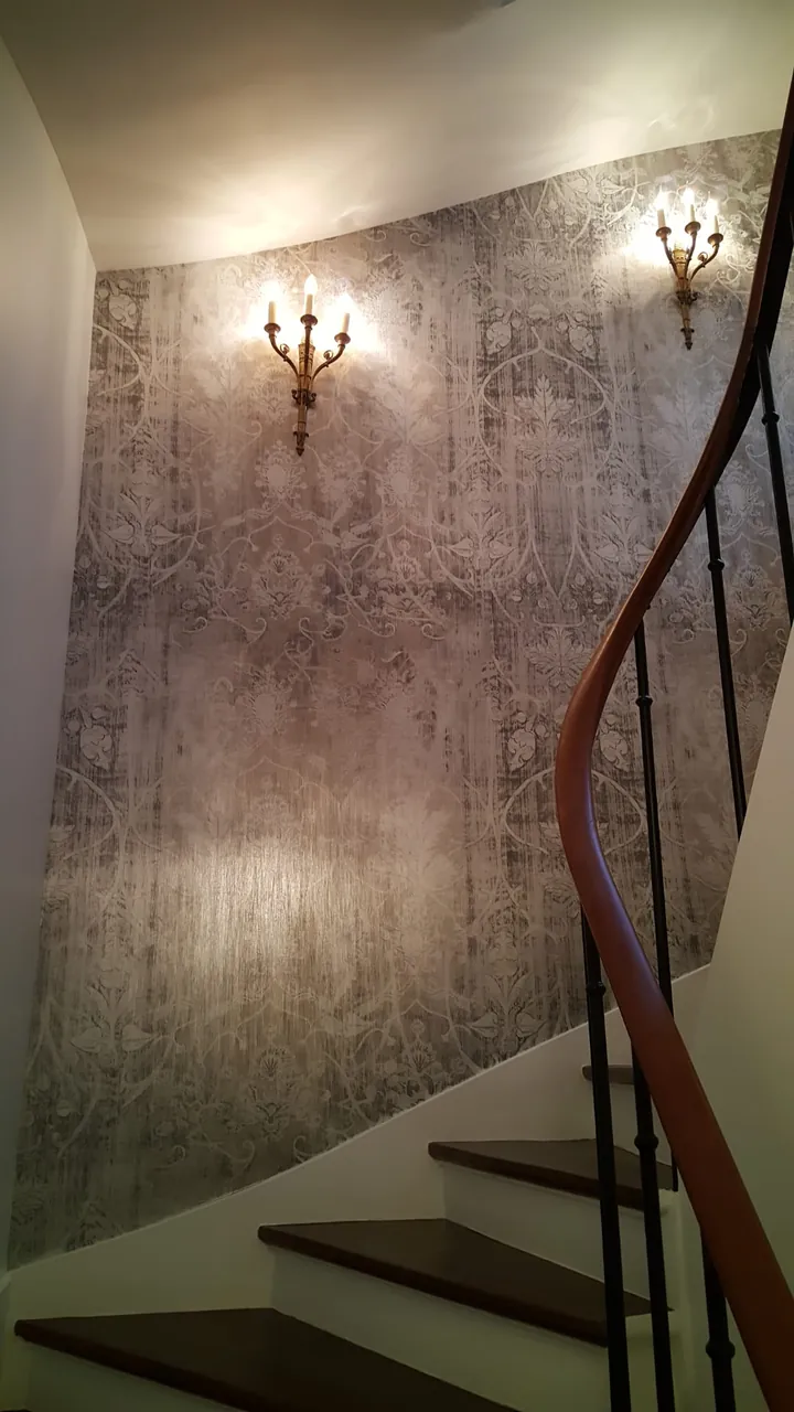 Cage d'escalier avec papier peint damassé et appliques