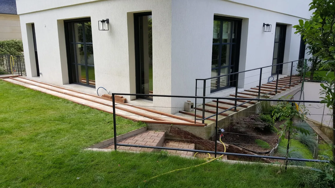 Terrasse extérieure avec dallage et jardin engazonné