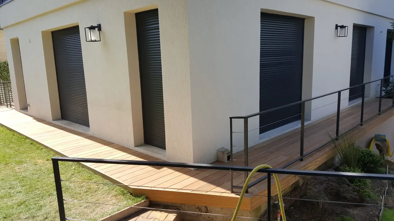 Terrasse en bois ipé avec garde-corps métallique autour d'une maison contemporaine